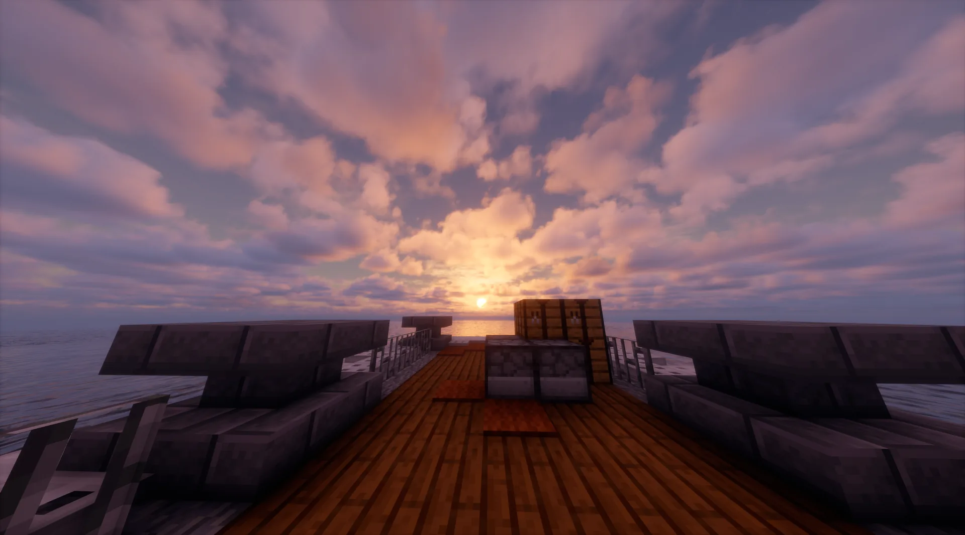 Cubierta de un barco frente a un amanecer sobre el mar con nubes abiertas